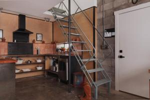 a kitchen with a ladder in the middle of a room at Industrial Artist Loft at Iconic Property in Marfa +24 photos
