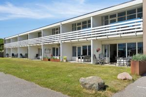 ein großes weißes Gebäude mit einer Wiese davor in der Unterkunft Feriehus 1122 in Ringkøbing
