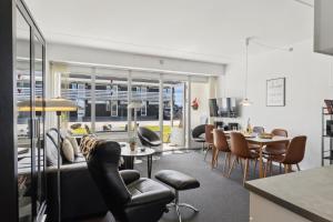 ein Wohnzimmer mit einer Couch sowie Tischen und Stühlen in der Unterkunft Feriehus 1122 in Ringkøbing