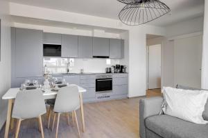 a kitchen and living room with a table and chairs at Modern and Stylish 1BR with Balcony and City View in Helsinki