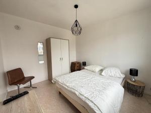 a bedroom with a bed and a chair in it at Maison 3 étoiles au centre des Sables d'Olonne avec accès plage, Wifi et garage - FR-1-197-519 in Les Sables-dʼOlonne