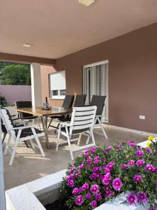 a patio with a table and chairs and purple flowers at Villa Vita in Mostar