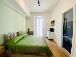 una camera da letto con un letto verde e un bagno di Domus 14 a Roma