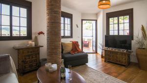 a living room with a couch and a tv at Casa Pegelow in Frigiliana