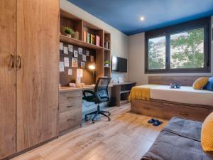 a bedroom with a bed and a desk with a computer at Livensa Living Studios Valencia Marina Real Hotel-Apartamento in Valencia