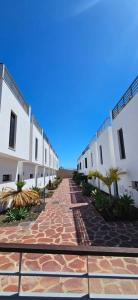 una calle adoquinada frente a edificios blancos en Adosado El Medano, en El Médano