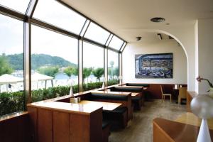 a restaurant with tables and chairs and large windows at Hotel Niza in Donostia-San Sebastián