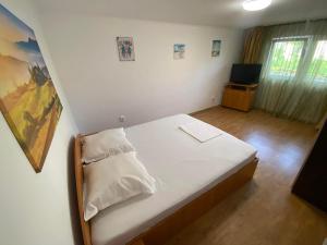 a bedroom with a white bed and a television at Apartament A2 - EVIM in Mangalia