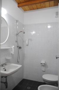 La salle de bains blanche est pourvue d'un lavabo et de toilettes. dans l'établissement Hotel Saint Tropez SPA & Restaurant, à Lido di Savio