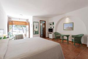 a bedroom with a bed and chairs and a table at Cortijo El Sotillo in San José
