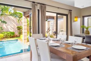 a dining room with a table and a swimming pool at Tropical Villa - 3 Bedrooms in the heart of Grand-Baie in Grand Baie