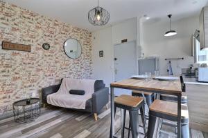 a living room with a table and a chair at Les Apparts du Pont Vert - lit double - WiFi - tout inclus - 7 in Troyes
