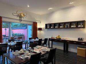 a restaurant with tables and chairs and a bar at Cactusberry Lodge in Cape Town