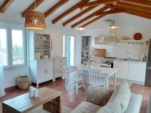 a kitchen and living room with a table and chairs at Casa Carlena in Supetar