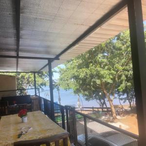 d'un balcon avec une table et une vue sur la plage. dans l'établissement CABAÑA ROHAYHU- Frente al rio Paraná -Coratei-Ayolas Misiones-Paraguay, à Ayolas