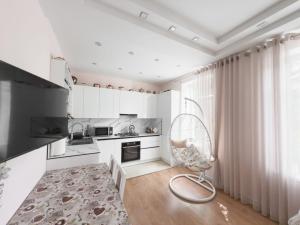 a white kitchen with a chair in a room at Central 2-Bedroom Cozy New Flat in Chişinău