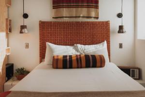 a bedroom with a white bed with a red headboard at Entire Private Boutique Motel w Courtyard and Sauna in Marfa