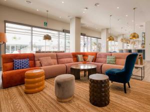 a living room with a couch and a table and chairs at Livensa Living Studios Valencia Marina Real Hotel-Apartamento in Valencia