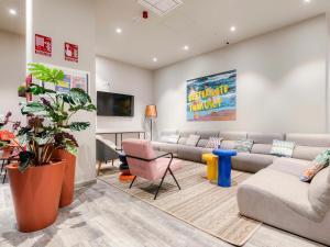 a large living room with a couch and chairs at Livensa Living Studios Valencia Marina Real Hotel-Apartamento in Valencia