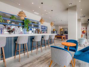 a bar in a restaurant with stools and chairs at Livensa Living Studios Valencia Marina Real Hotel-Apartamento in Valencia