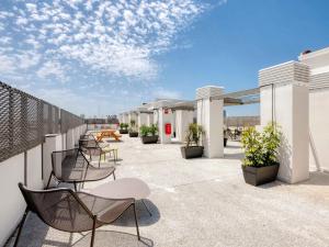 a patio with chairs and tables on a building at Livensa Living Studios Valencia Marina Real Hotel-Apartamento in Valencia