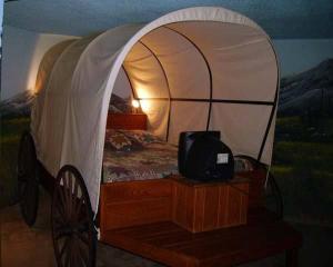 a bedroom with a tent with a tv in it at Red Carpet Inn Fanta Suites Hotel in Greenwood