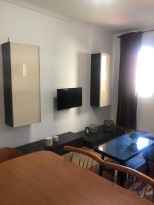 a dining room with a table and a television on the wall at Gaviota 2do in Marín