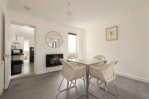 ein Esszimmer mit Glastisch und Stühlen in der Unterkunft Lovely 2 Bed House in Grays 4 Separate Beds in Grays Thurrock