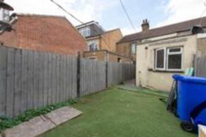 ein Hof mit Zaun und ein Haus mit einer blauen Tonne in der Unterkunft Lovely 2 Bed House in Grays 4 Separate Beds in Grays Thurrock