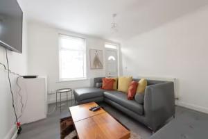 ein Wohnzimmer mit Sofa und Tisch in der Unterkunft Lovely 2 Bed House in Grays 4 Separate Beds in Grays Thurrock