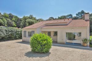 a house with a bush in front of it at Villa Familiale Proche Plage & Forêt avec Piscine Privée à Jard sur Mer in Jard-sur-Mer