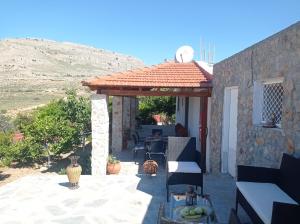 a stone house with a pergola on a patio at Tassos Holiday home in Archangelos