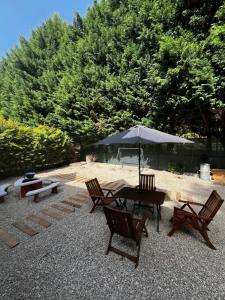 a patio with a table and chairs and an umbrella at Bay House Balaton in Balatonfůzfő