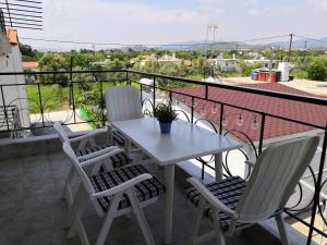 a white table and chairs on a balcony at Almond Apartments in Orfánion
