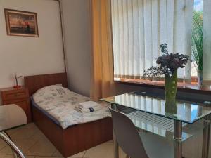 a room with a glass table with a vase of flowers at Studio Rynek Pułtusk in Pultusk