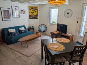 a living room with a blue couch and a table at Charmante maison proche Hôtel de ville in Angoulême
