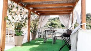 a patio with chairs and tables and potted plants at Domo Marzellinu in Orosei