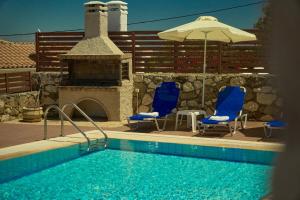 a swimming pool with two chairs and an umbrella at Casa Livia - Secluded Stone Villa with Private Pool and Panoramic Sea Views in Tragaki
