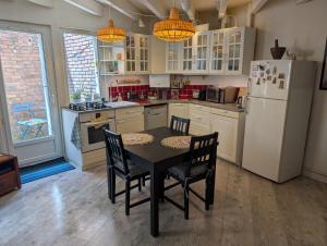 a kitchen with a table and chairs and a refrigerator at Charmante maison proche Hôtel de ville in Angoulême +14 photos