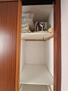 a closet with white shelves and a wooden door at Un ático duplex con terraza grande al lado del mar in Lloret de Mar