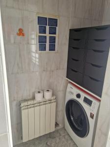 a washing machine in a bathroom with two rolls of toilet paper at Un ático duplex con terraza grande al lado del mar in Lloret de Mar