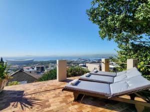 a patio with two beds on a roof at Bluegum Hill Guesthouse & Apartments in Cape Town +171 photos