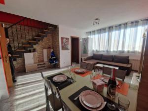 a living room with a dining table and a couch at Un ático duplex con terraza grande al lado del mar in Lloret de Mar