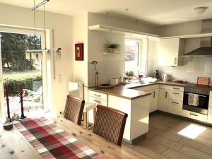 a kitchen with white cabinets and a table and chairs at "Villa Lorenzo" in Bad Zwischenahn