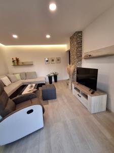 a living room with a couch and a flat screen tv at APARTMAN EDDA **** in Labin