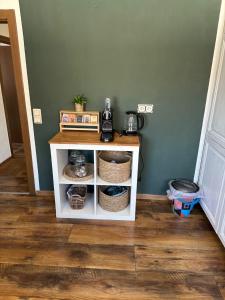 a small white cabinet with baskets on it in a room at Daddy's home in Hargesheim