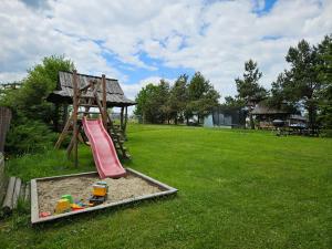 a playground with a slide in the grass at U Młynarczyków in Dębno