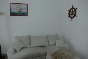 a white couch in a living room with a picture on the wall at Kapitänshaus Schäfer App Steuermann in Brunsbüttel