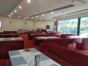 a restaurant with red chairs and tables and windows at CV Resort in Sonprayag