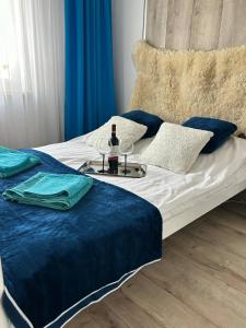 a bed with a tray with a bottle of wine on it at BM Apartament in Augustów